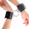 Kink – Appui-poignets fixes avec anneau et fermeture par cadenas noir ajustable 16-23 cm x 5,5 cm – BDSM & fétichisme