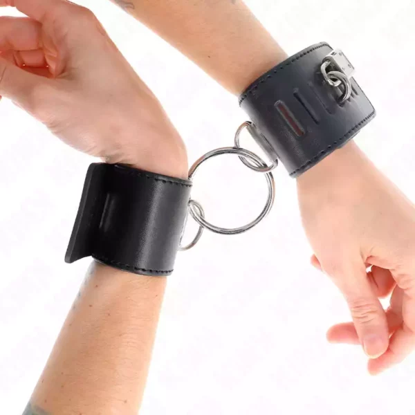 Kink – Appui-poignets fixes avec anneau et fermeture par cadenas noir ajustable 16-23 cm x 5,5 cm Kink – Appui-poignets fixes avec anneau et fermeture par cadenas noir ajustable 16-23 cm x 5,5 cm – BDSM & fétichisme